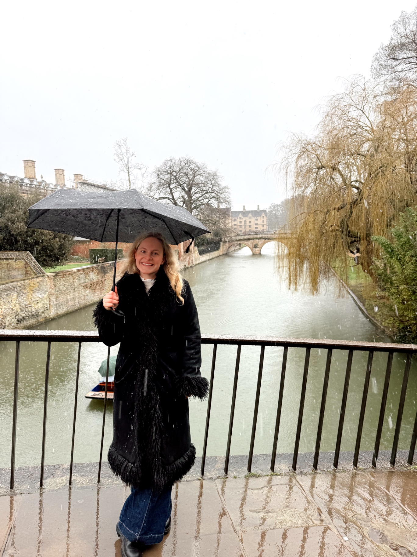 Evie stood on a stone bridge in Cambridge at golden hour
